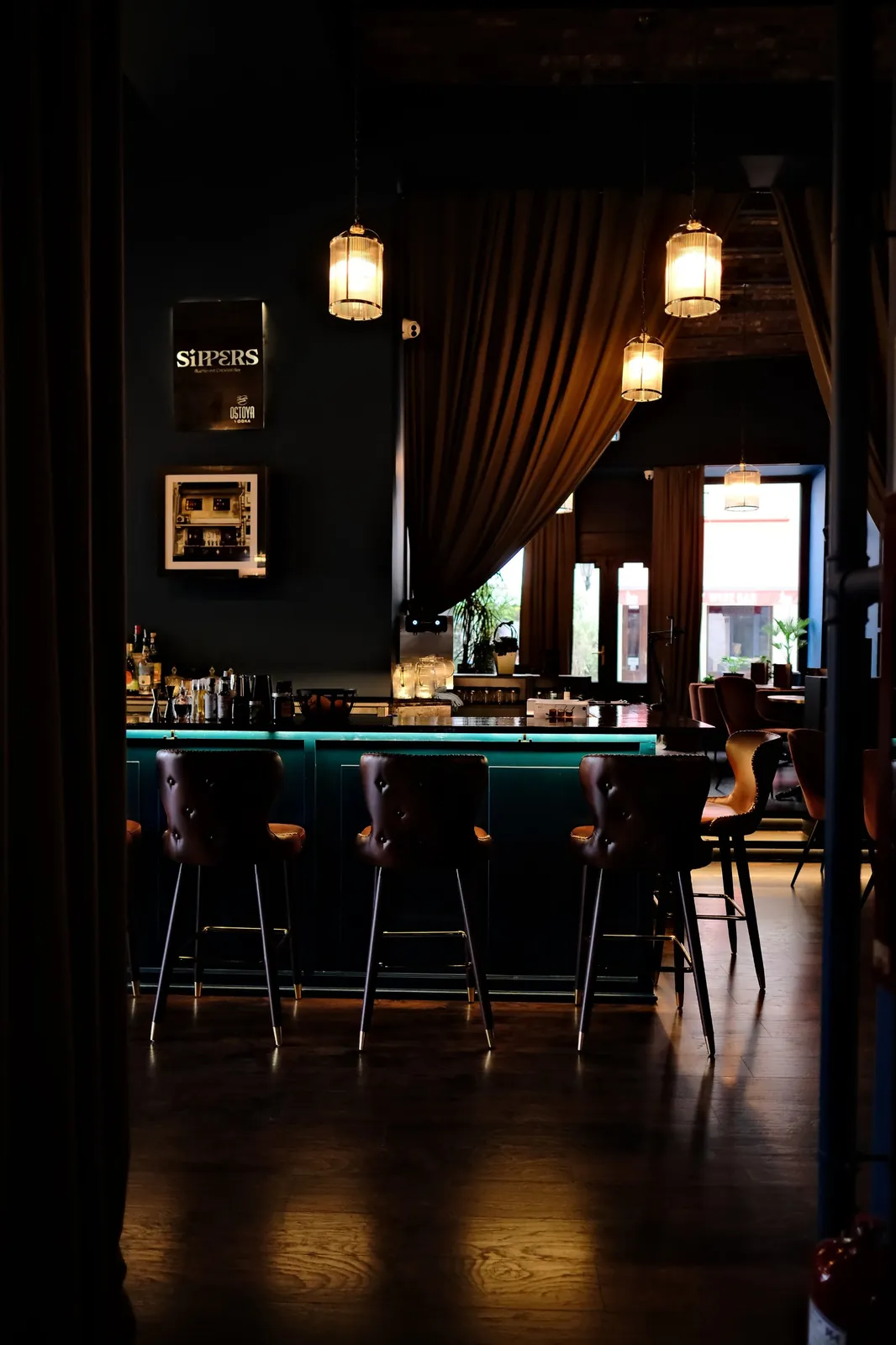 The Sippers bar counter and pendant lights seen through velvet curtains, Covaci 23, Bucharest